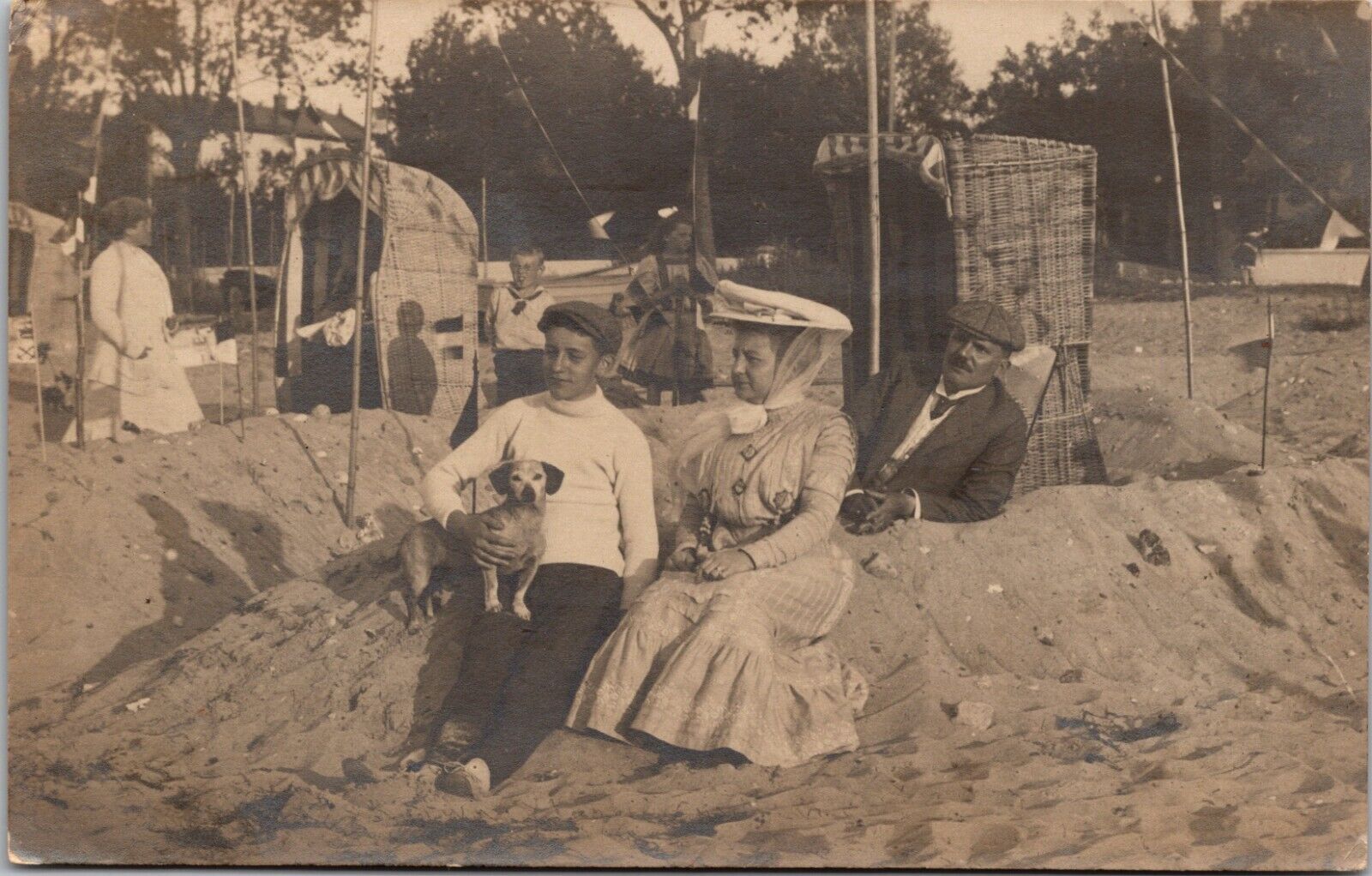 VINTAGE 1911 RPPC- FAMILY WITH SMALL DOG ON BEACH-LAKE IN VINTAGE DRESS